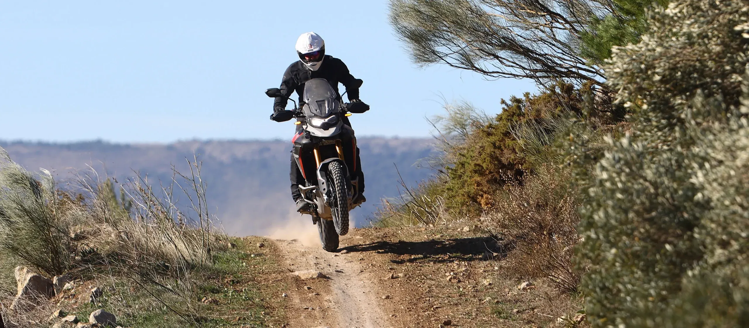 Bret Tkacs rides a Triumph Tiger along a dusty hillside track at the bike's press launch, Spain