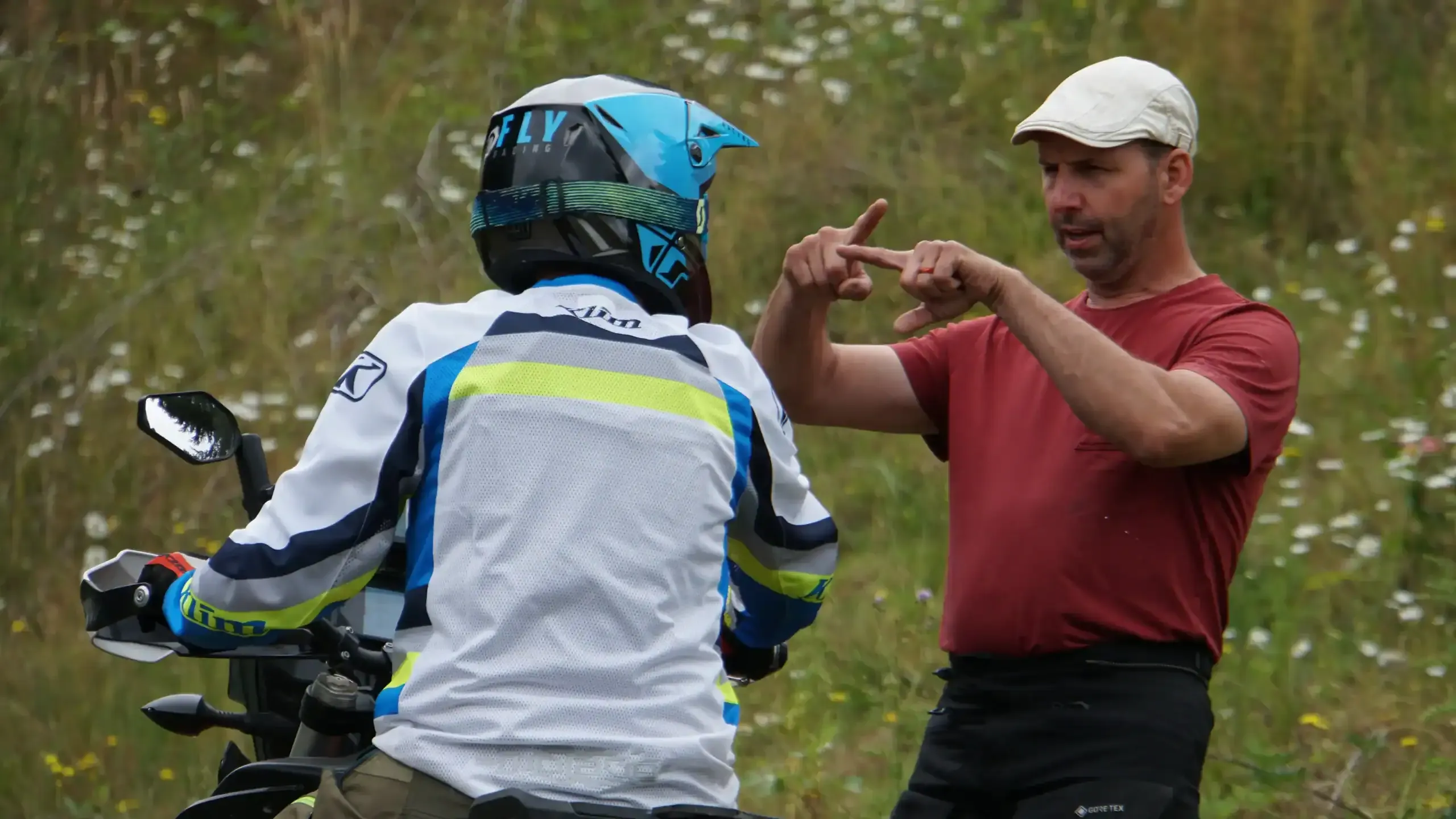 Bret Tkacs explains a technique with his hands to a student on a motorcycle, Oregon
